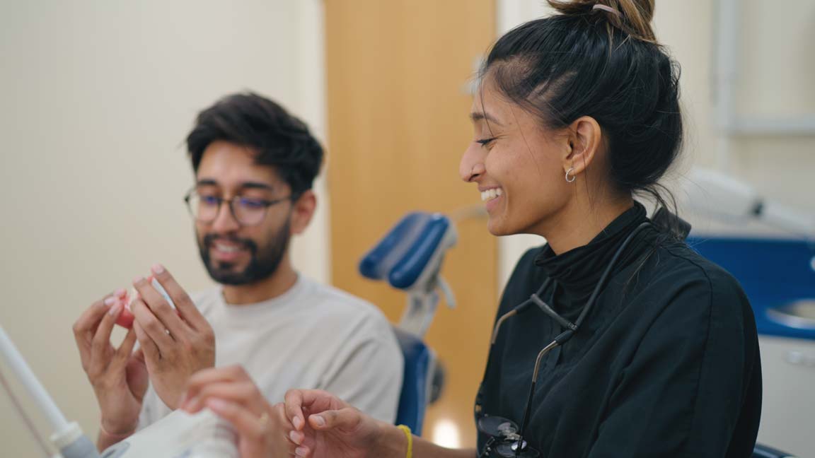 A smiling cosmetic dentist with a happy patient.
