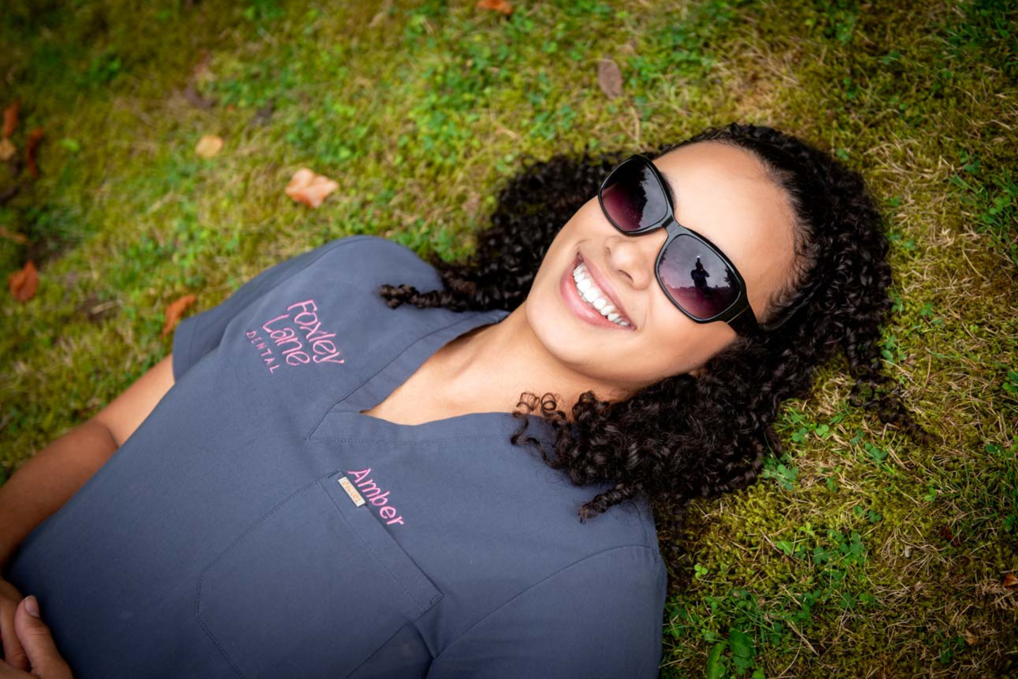 Dental nurse Amber from Foxley Lane Dental smiling outdoors wearing sunglasses at dental practice in Purley