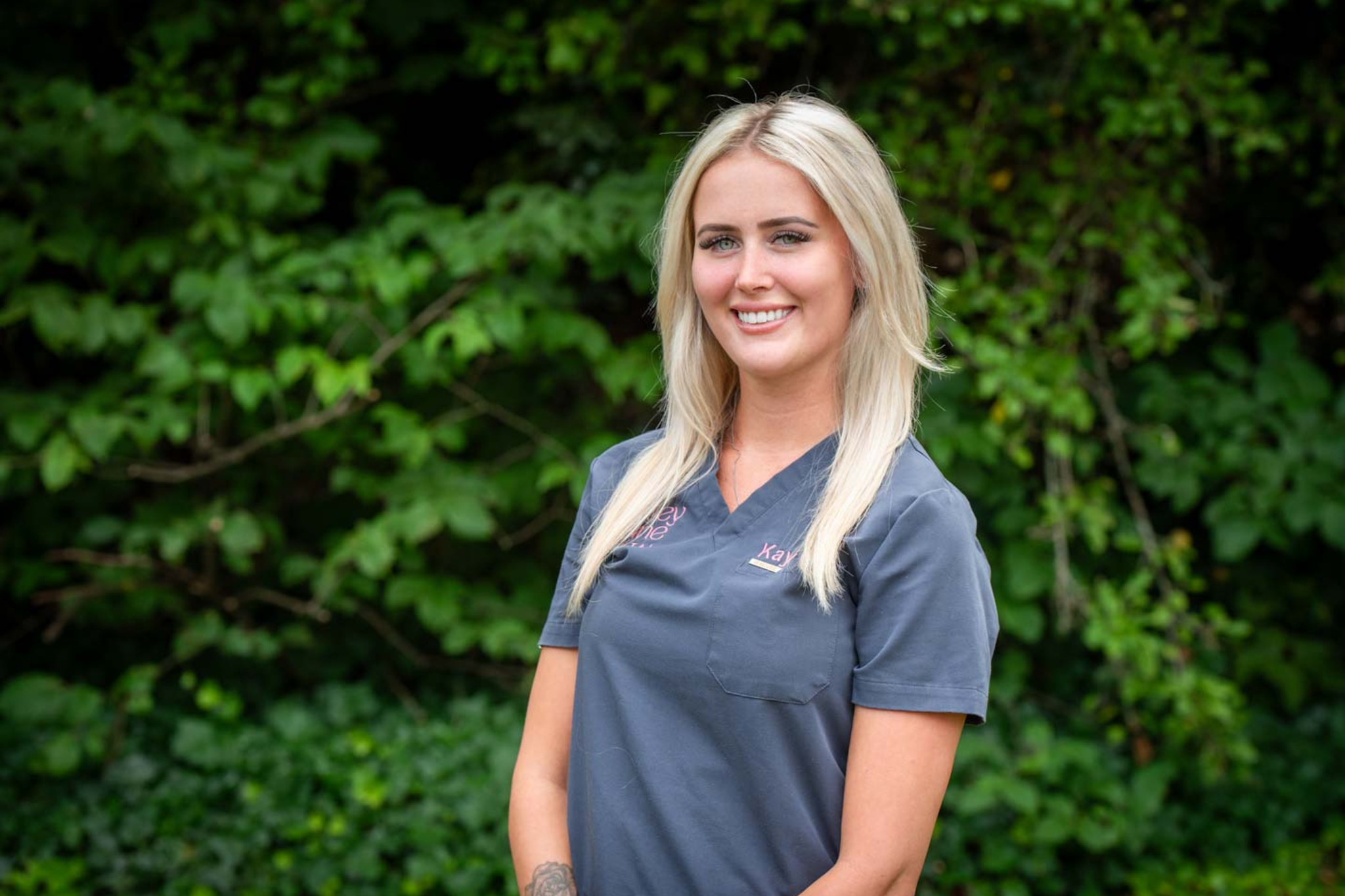 Dental nurse Kayleigh Woolacott from Foxley Lane Dental in Purley smiling outdoors in practice scrubs