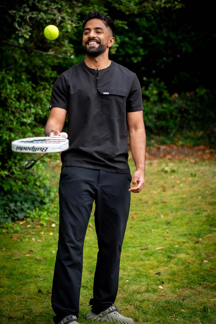 Dr Nev Jeyakumar, dental implant specialist, enjoying a light moment outdoors at the Purley practice