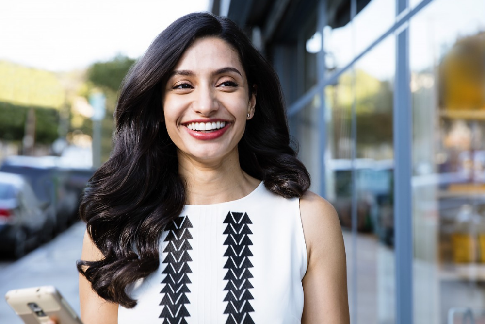 Woman smiling confidently after Invisalign clear aligner treatment