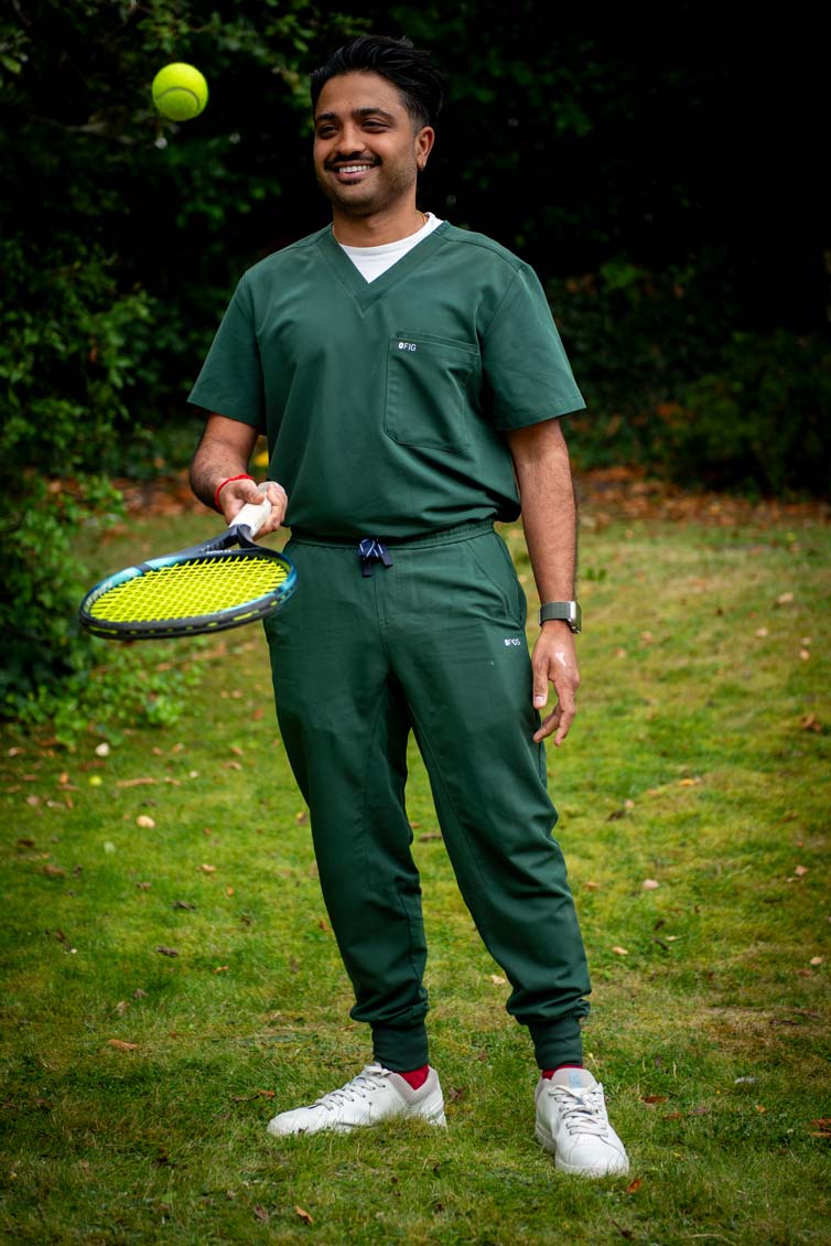 Dentist Ankit Patel outdoors in green scrubs, reflecting a relaxed and approachable dental team.