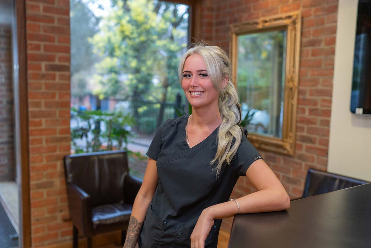 Friendly dental receptionist in modern dental clinic, smiling and ready to welcome patients at Foxley Lane Dental in Purley.