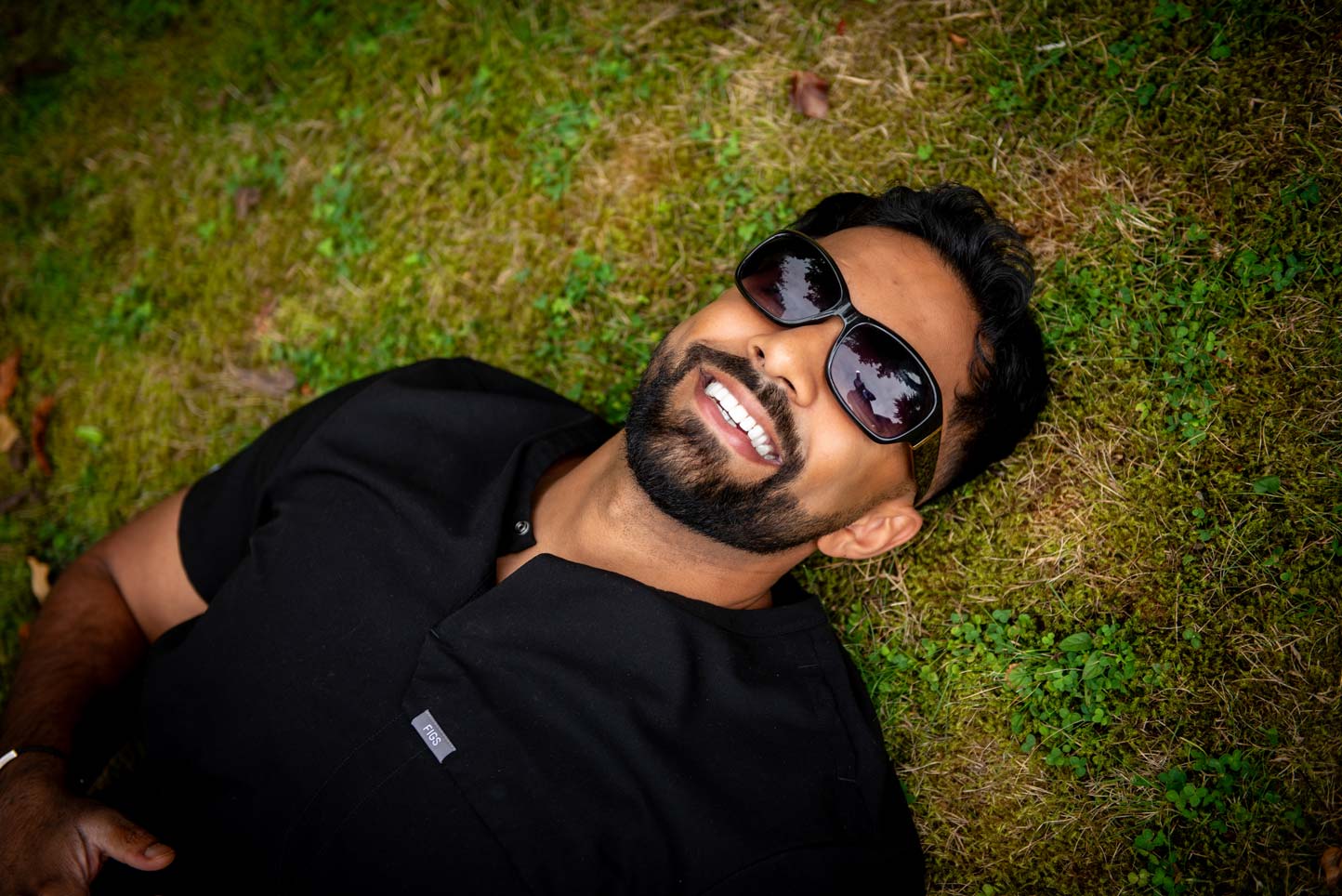 Dr Nev, experienced Invisalign provider at Foxley Lane Dental, relaxing outdoors, representing discreet Invisalign treatment for adult cosmetic smile improvement in Purley