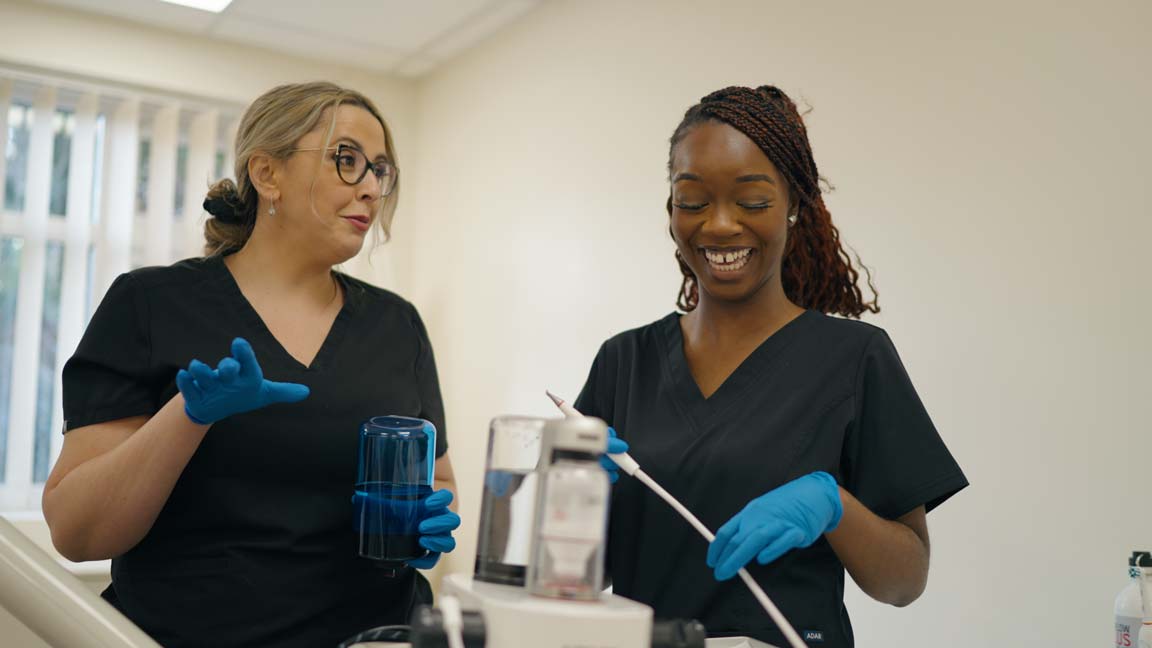 Two smiling dental nurses at Foxley Lane Dental preparing for treatment, showcasing a welcoming and professional clinic environment.