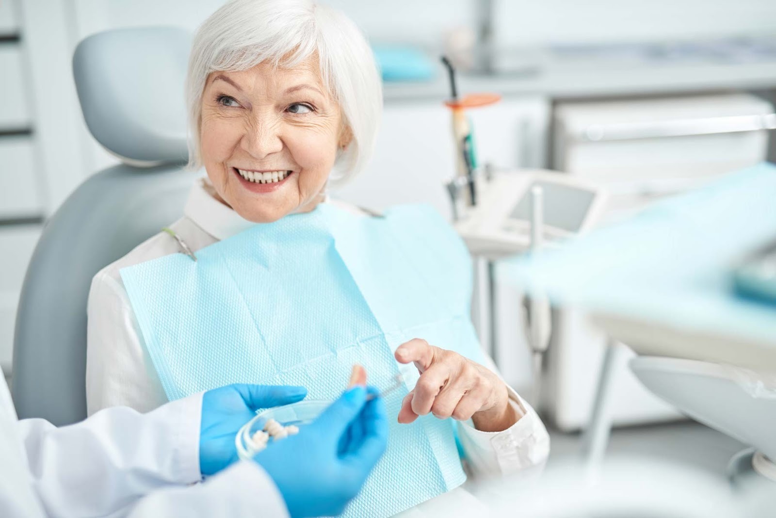 Dentist discussing tooth replacement options with older patient during consultation in Purley