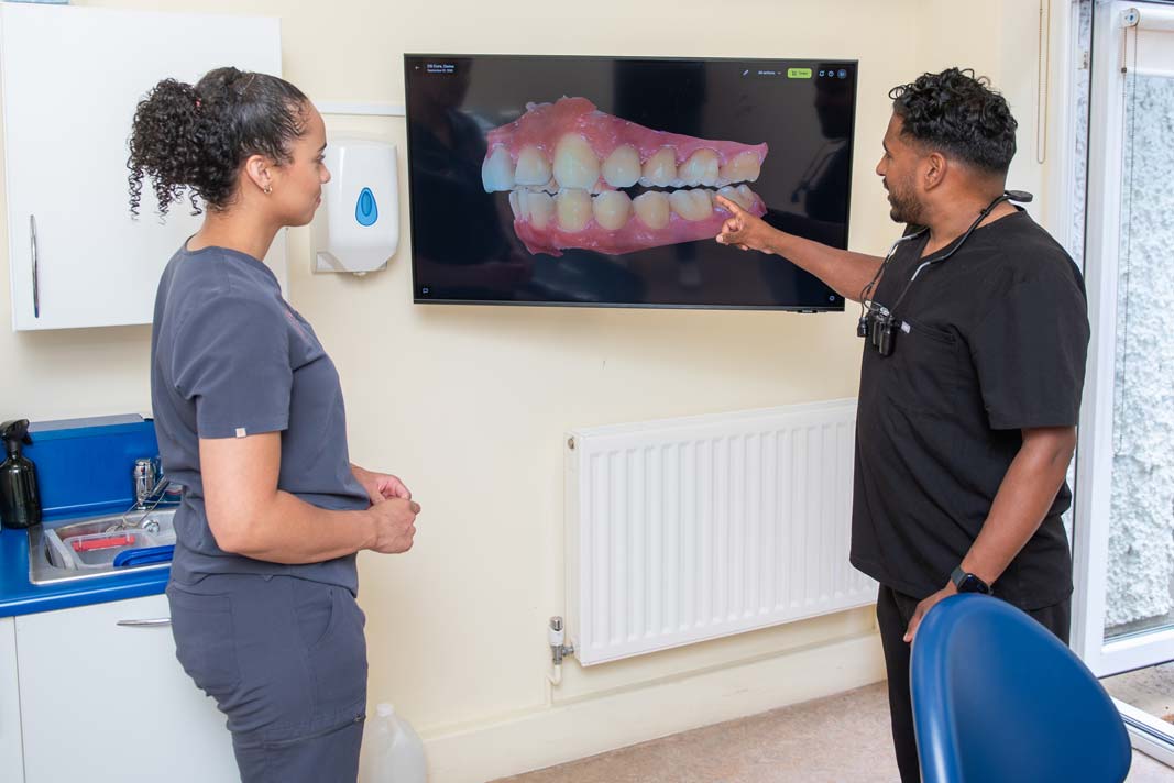 Dr Nev Jeyakumar discussing Invisalign treatment with a dental nurse in the Purley clinic