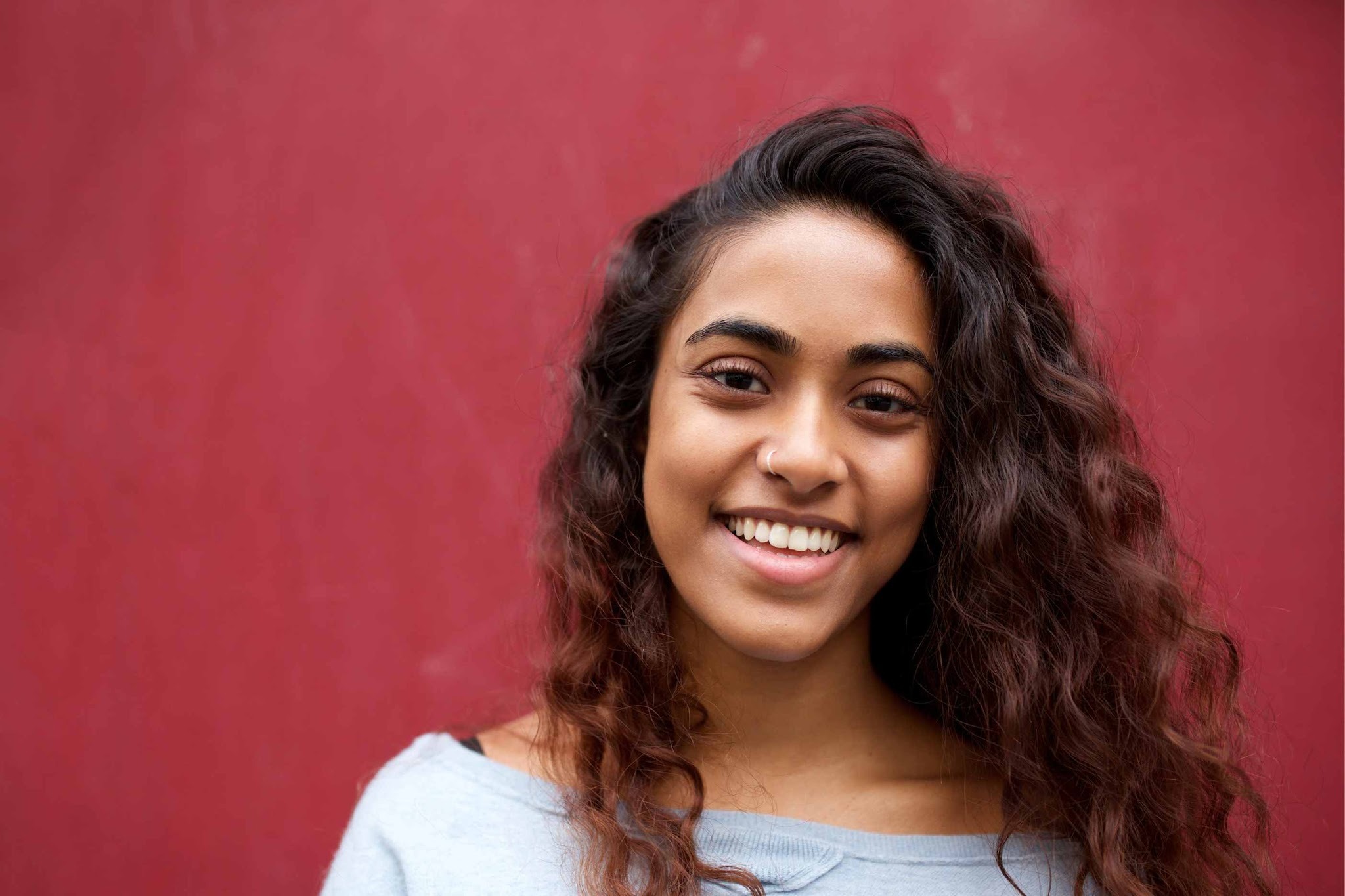 Patient showing natural-looking smile after porcelain veneers treatment in Purley