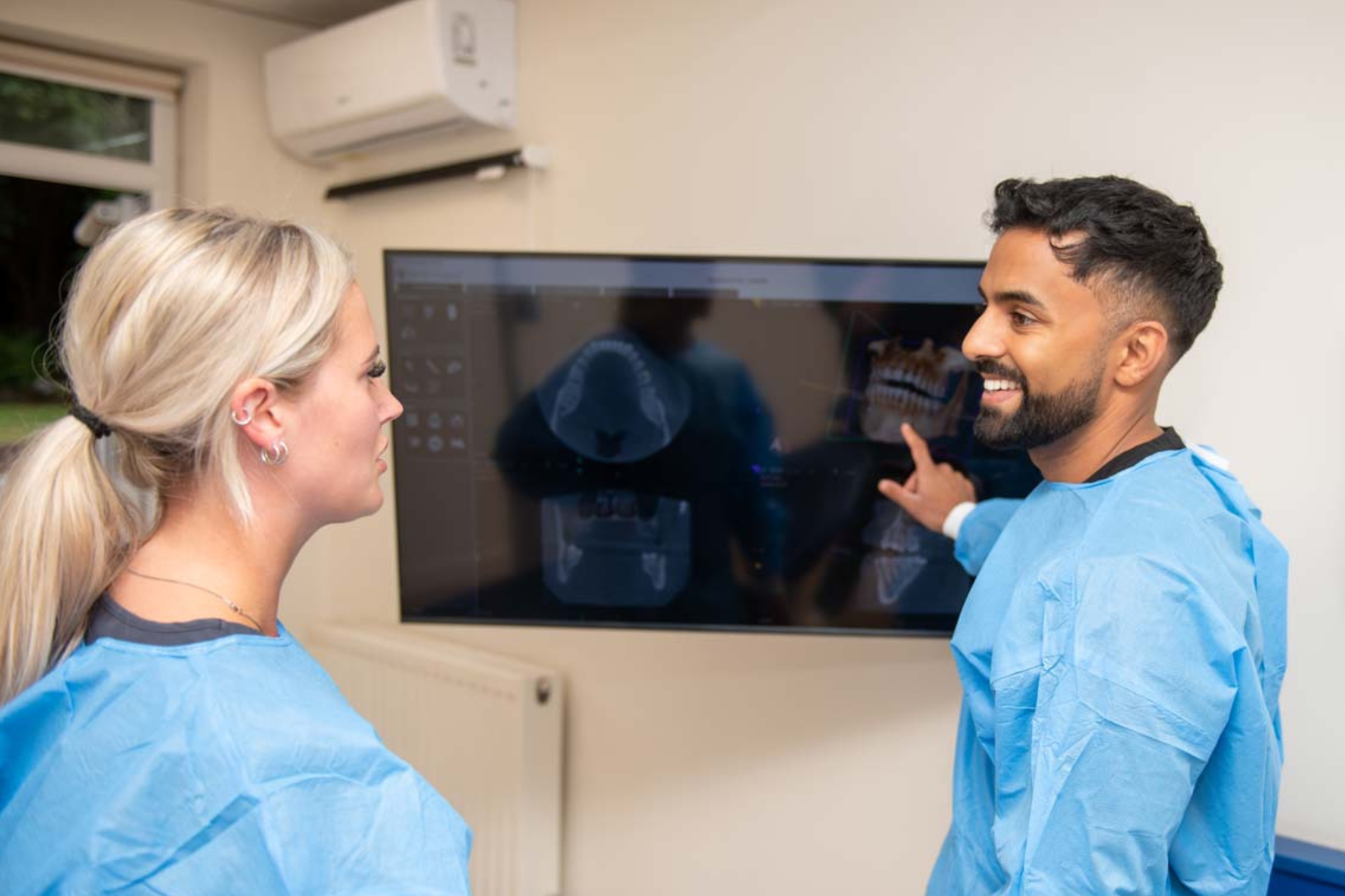 Dr Nev Jeyakumar discussing full mouth dental implant treatment planning with patient at Foxley Lane Dental Purley