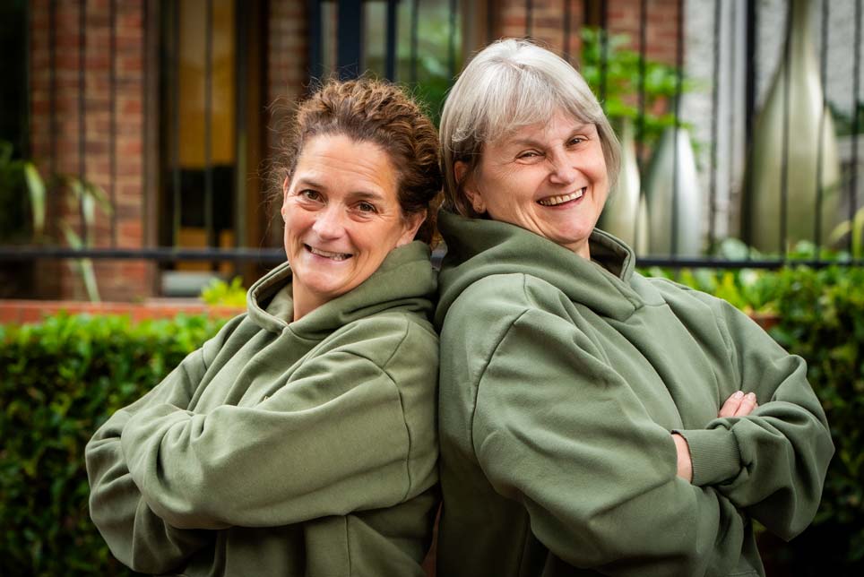 Dental hygienists Vicky Harris and Karen Phillips smiling together outside the practice