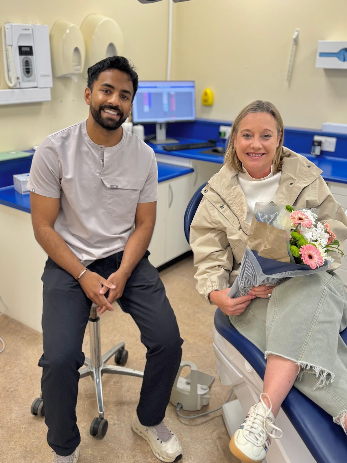 Foxley Lane Dental implant dentist with a happy patient holding flowers after successful treatment in a modern clinic setting.