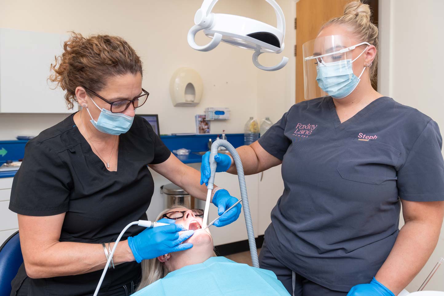 Dental hygienist Vicky Harris and dental nurse Steph working together during a patient treatment at the Purley dental practice