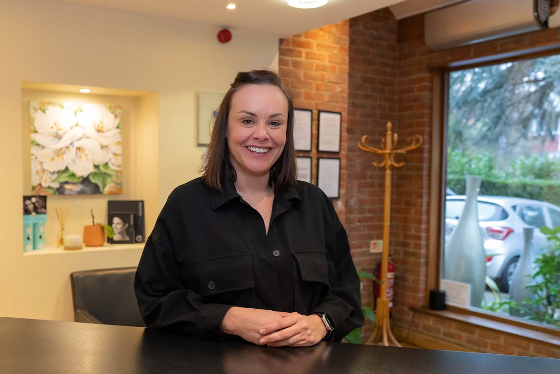 Receptionist at Foxley Lane Dental in Purley greeting patients with a warm smile at the front desk