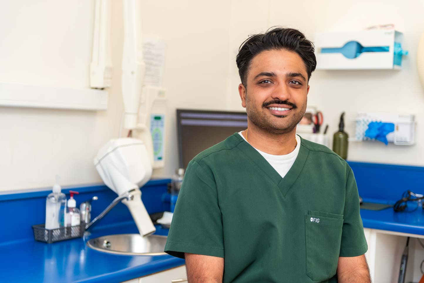 Dentist Ankit Patel discussing porcelain veneer options during a cosmetic dental consultation at Foxley Lane Dental
