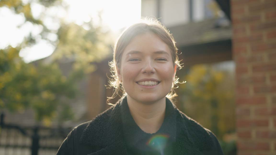 Smiling woman with wonderful teeth in the dappled sunshine.